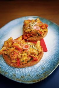 Topinka Masová dekandence, topinková směs z kuřecího masa (100g) s pečenou paprikou, pošírovaný žloutek